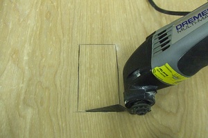 dremel-multi-max-tool-cutting-out-the-back-of-a-cabinet-for-outlet-copy